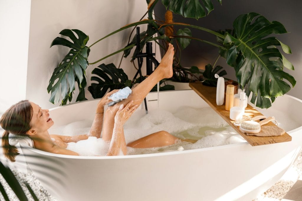 Side view of young woman bathing and taking care of her skin at luxury spa resort
